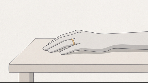 A thin gold band on a woman's ring finger